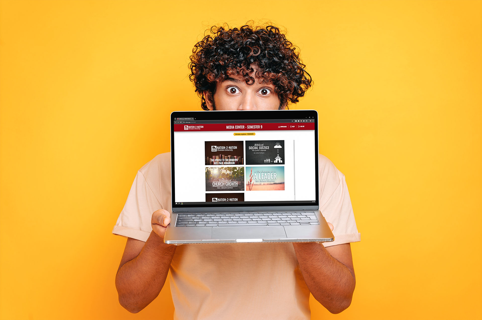 Young man presenting a laptop featuring the nation to nation media center.
